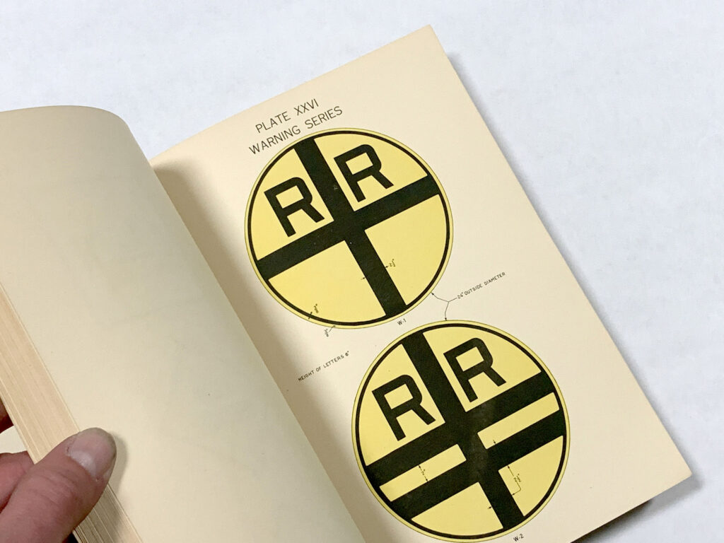 Open manual page showing railroad crossing sign examples.