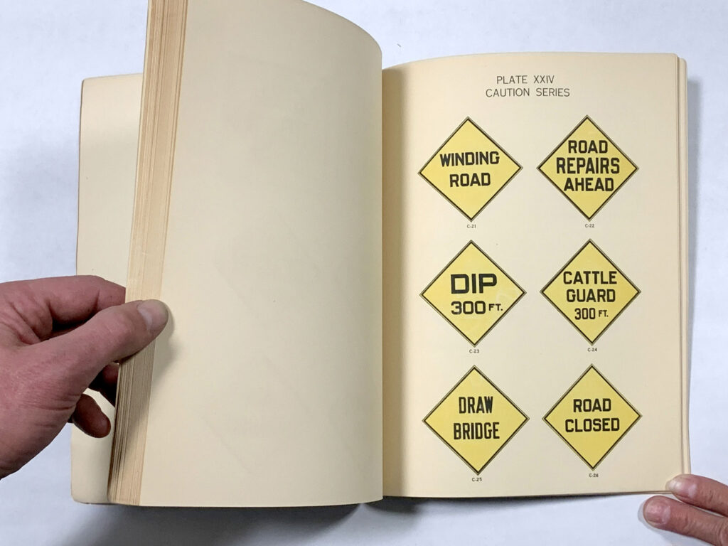 Open manual page showing yellow warning sign designs.