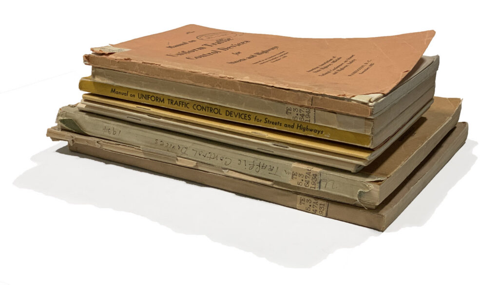 Stack of highway and traffic-control manuals used as research source material.