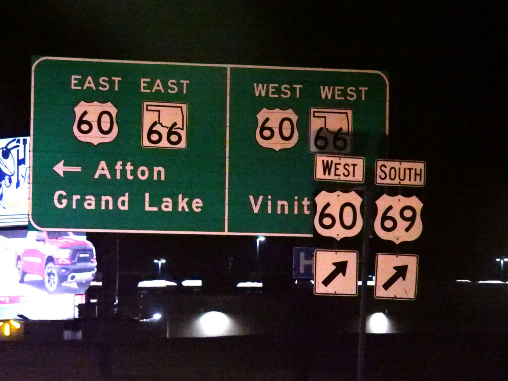 A cluster of overhead route signs points toward Afton, Grand Lake, and Vinita.