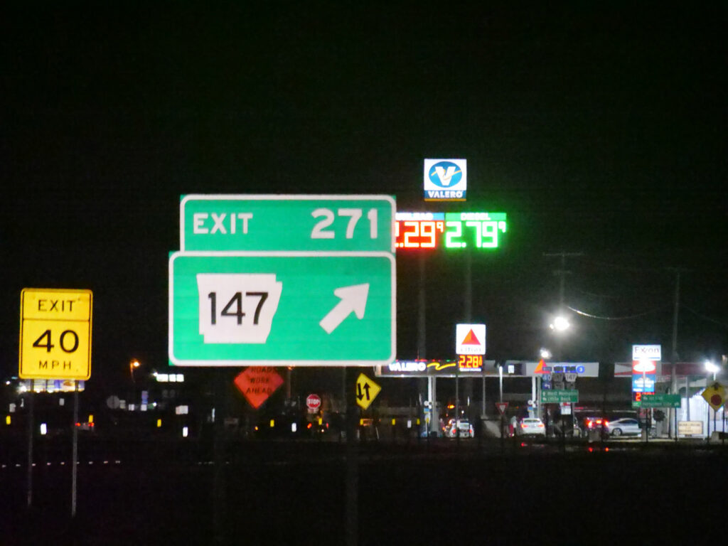 A nighttime highway sign directs traffic toward Exit 271 and Route 147.