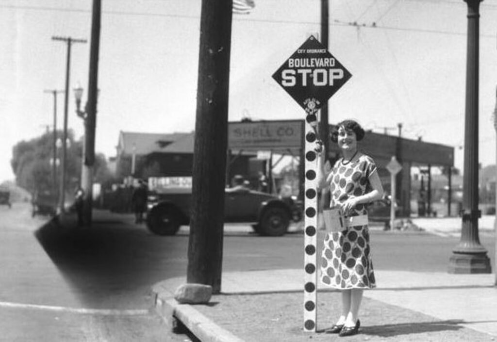 Historical Boulevard Stop sign with a woman standing beside the signpost.