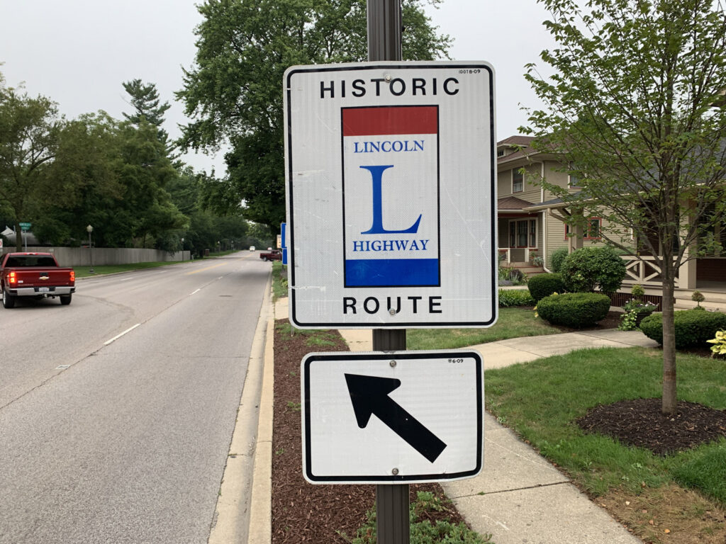 Historic Lincoln Highway route marker sign with arrow.
