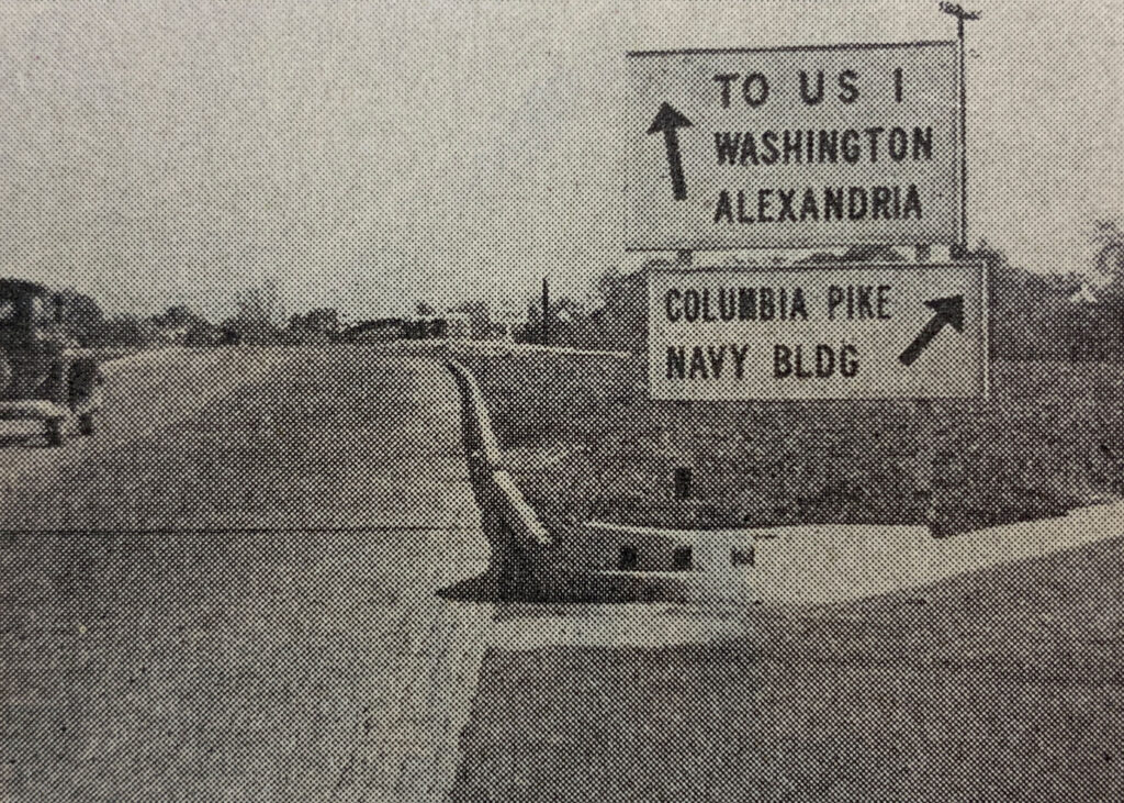 Archival photograph showing directional signs to Washington, Alexandria, and Navy Building.